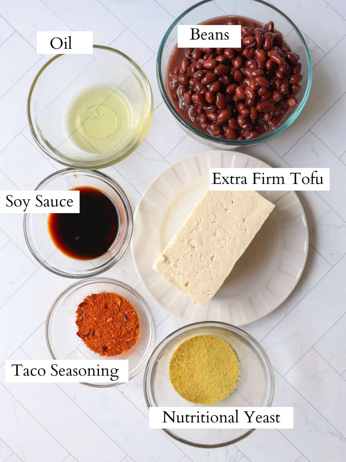 Ingredients for vegan tofu tacos laid out on a counter in individual glass bowls.