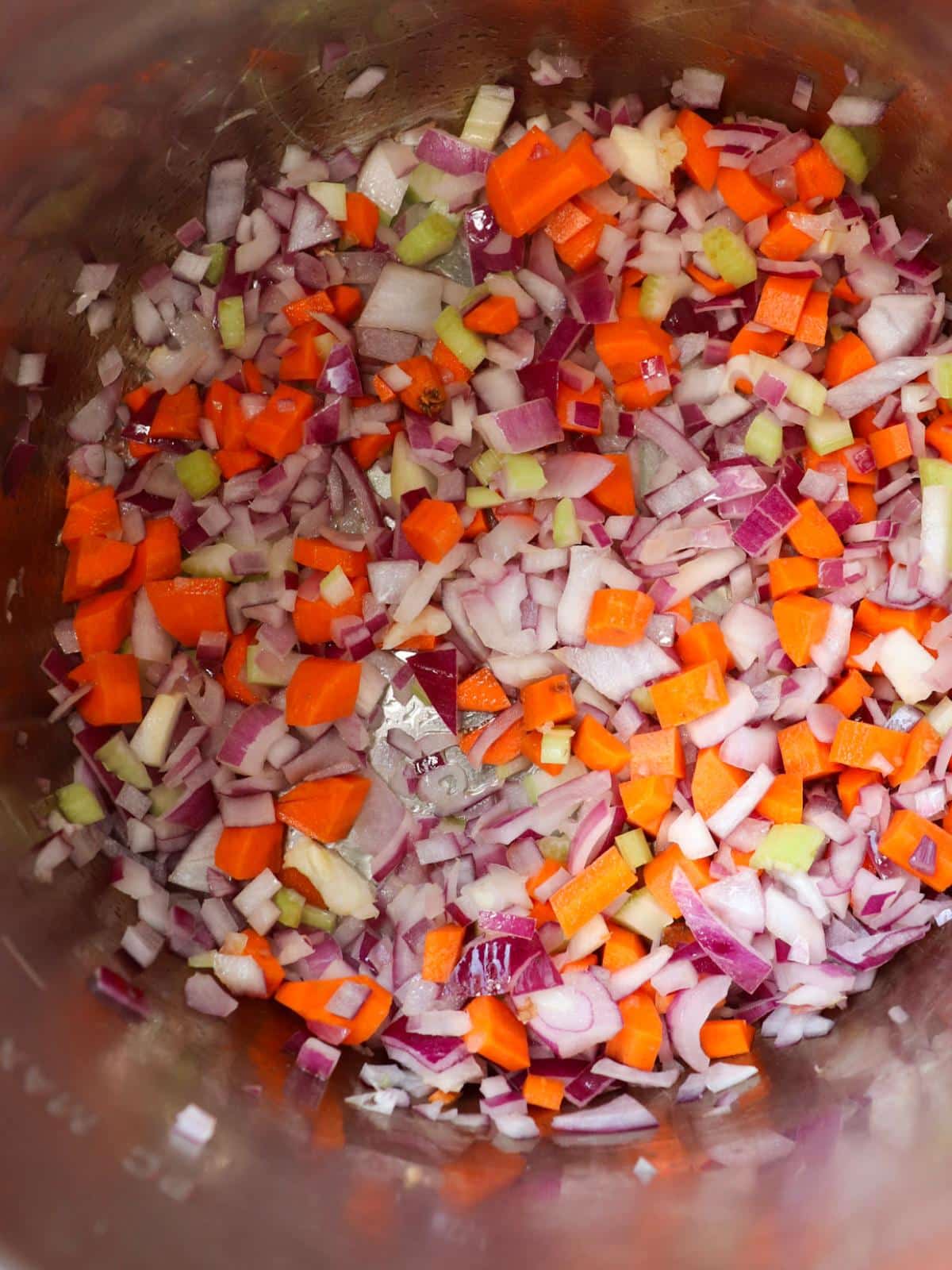 Carrots celery and onions sautéing in an instant pot.