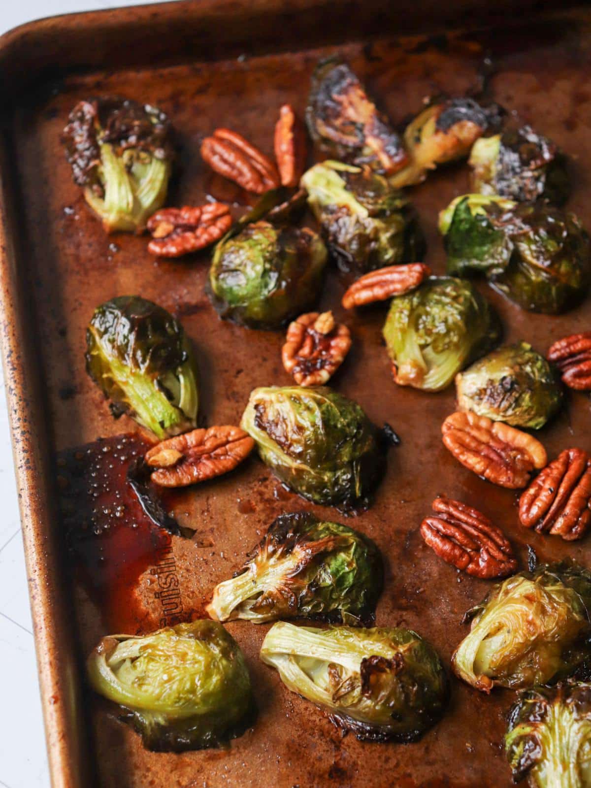 Maple balsamic candied brussel sprouts on a baking tray after being roasted.