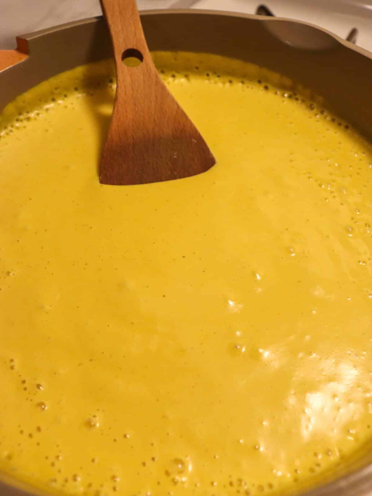 Vegan nacho cheese in a sauce pan on the stove.