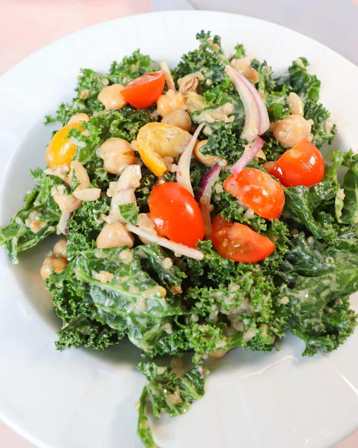 Kale salad with tahini dressing and quinoa in a bowl.