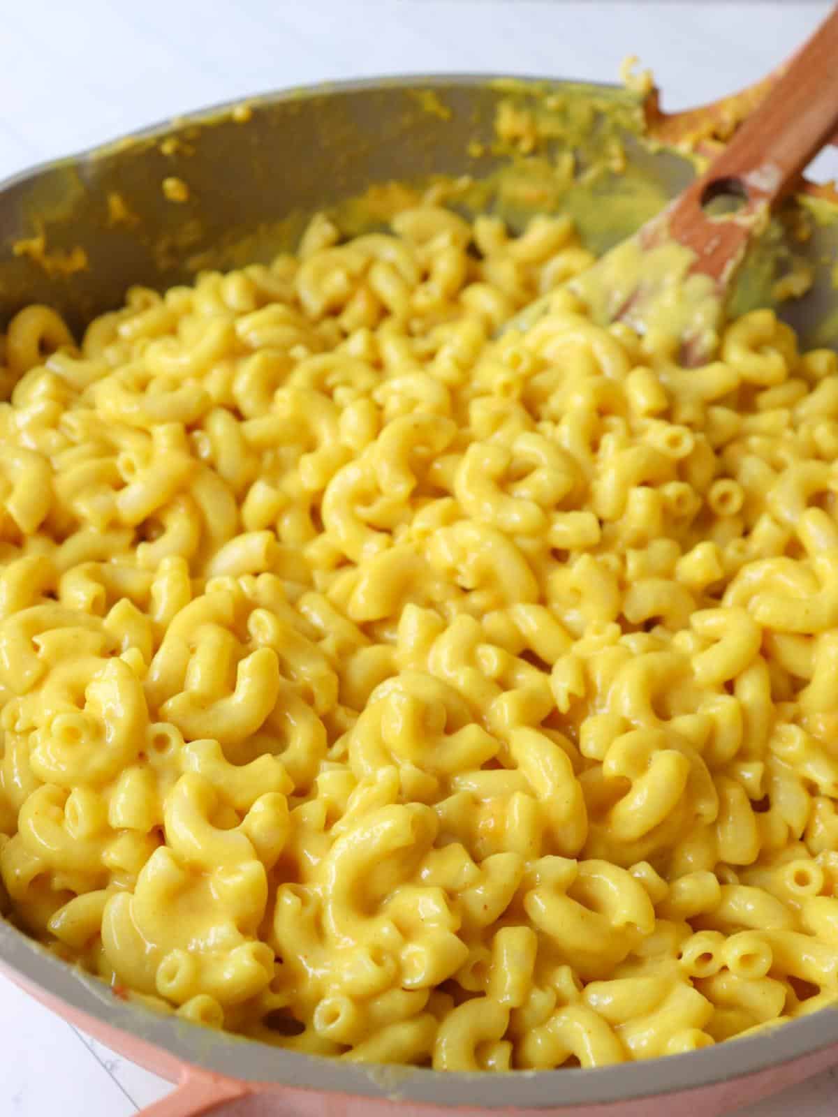 Dairy free mac and cheese in a pan on the stove.