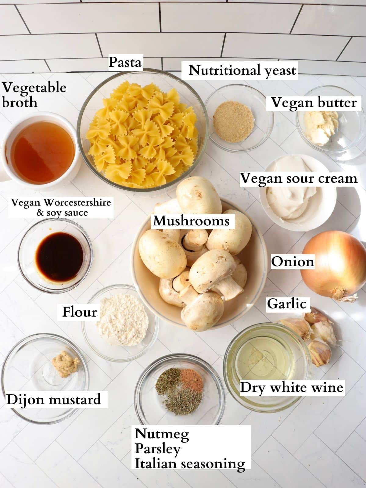 Ingredients for vegan mushroom stroganoff in small bowls on a kitchen counter.