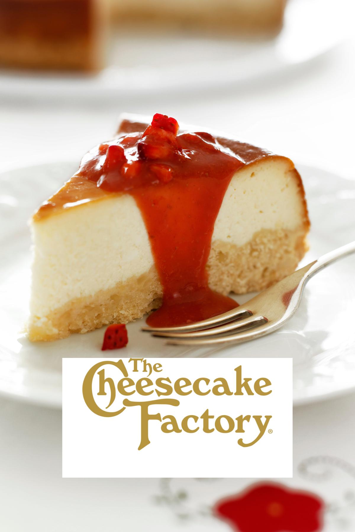 A slice of cheesecake topped with strawberry syrup with the Cheesecake Factory logo on it. 