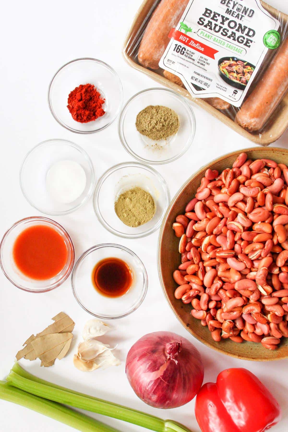 Ingredients for vegan red beans and rice laid out on a table in their separate bowls. 