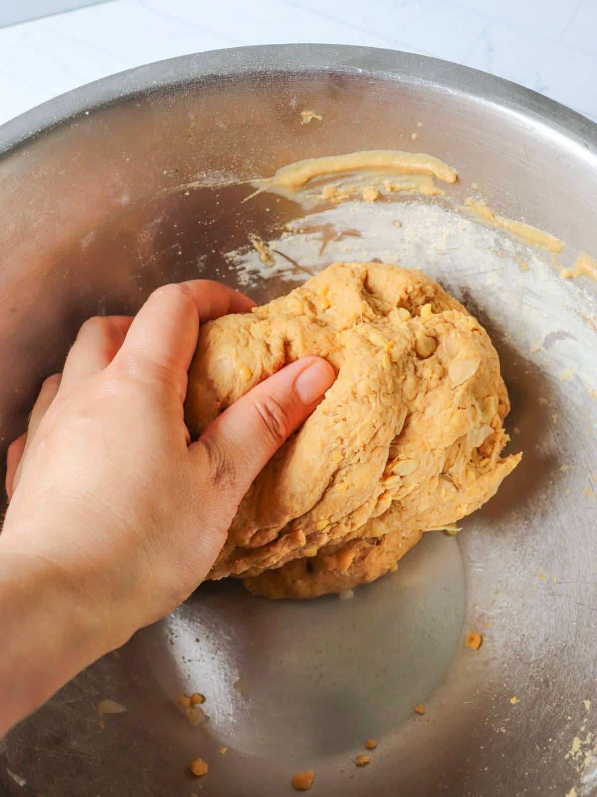 Hand kneading a ball of seitan dough.