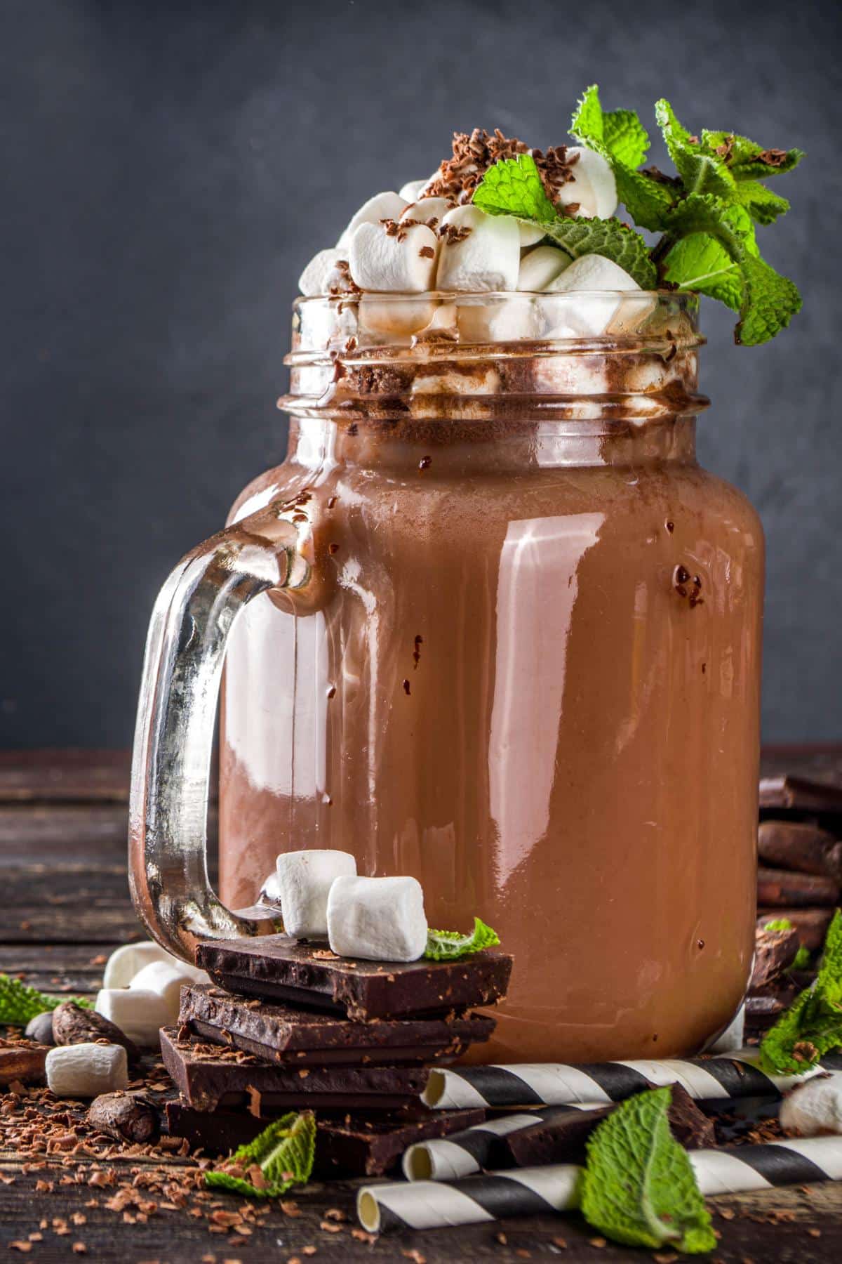 Mason jar of a thin mint smoothie topped with mint leaves.